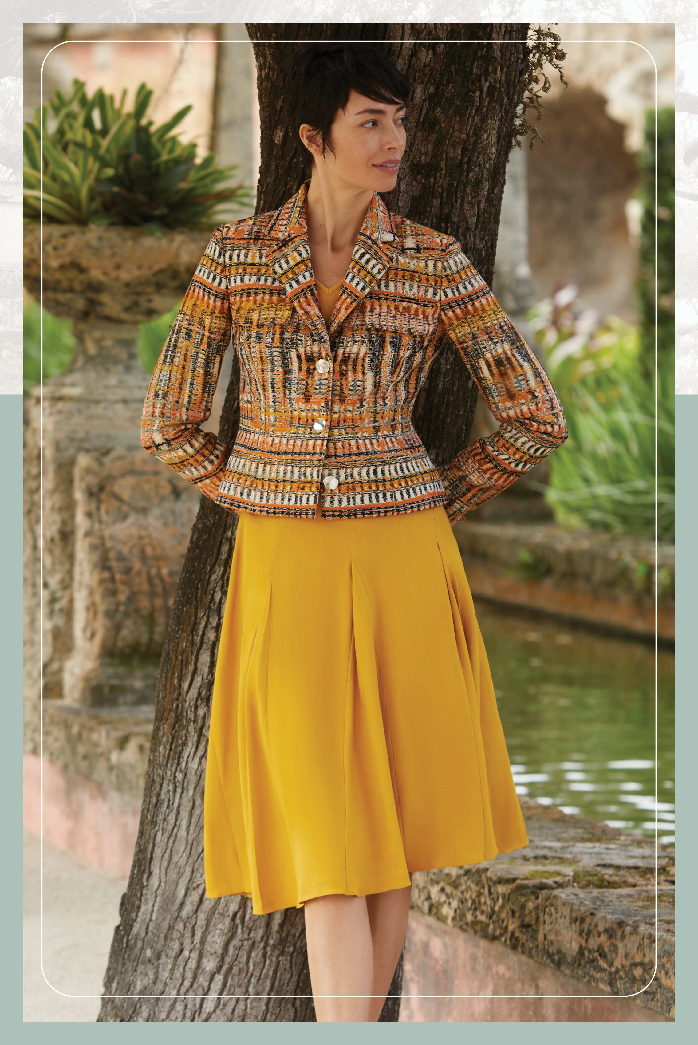 Photo of a model wearing the Letizia jacket, a metallic French jacquard jacket. Also the El Dorado skirt, a wide-sweep Italian stretch linen skirt.
