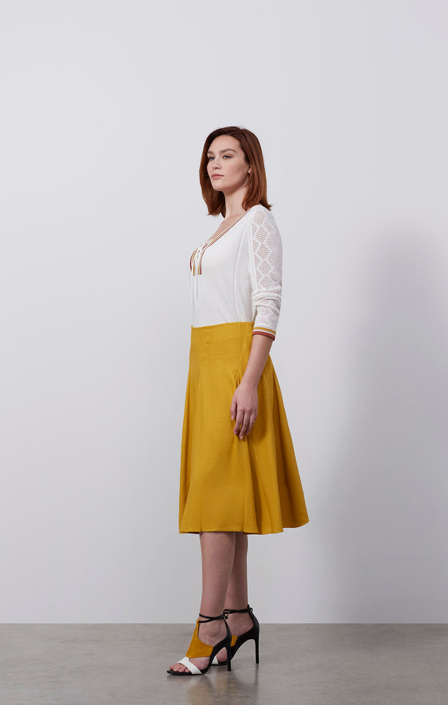 Ecomm photo of a model wearing the El Dorado skirt, which is a wide-sweep Italian stretch linen skirt.