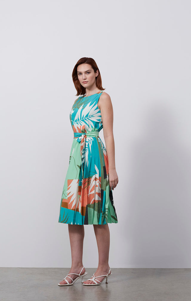 Ecomm photo of a model wearing the Jardiniere dress, which is a tropical-print, stretch silk pleated dress.