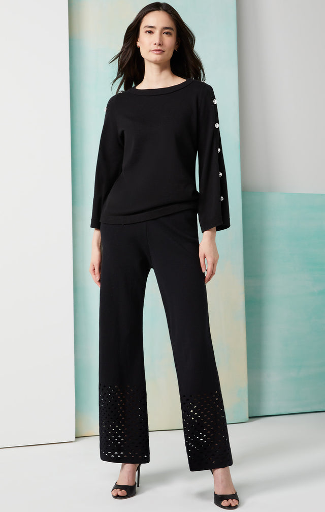Lookbook photo of a model wearing the Vibrato pants, which is a knit cotton pants with open triangle stitches.