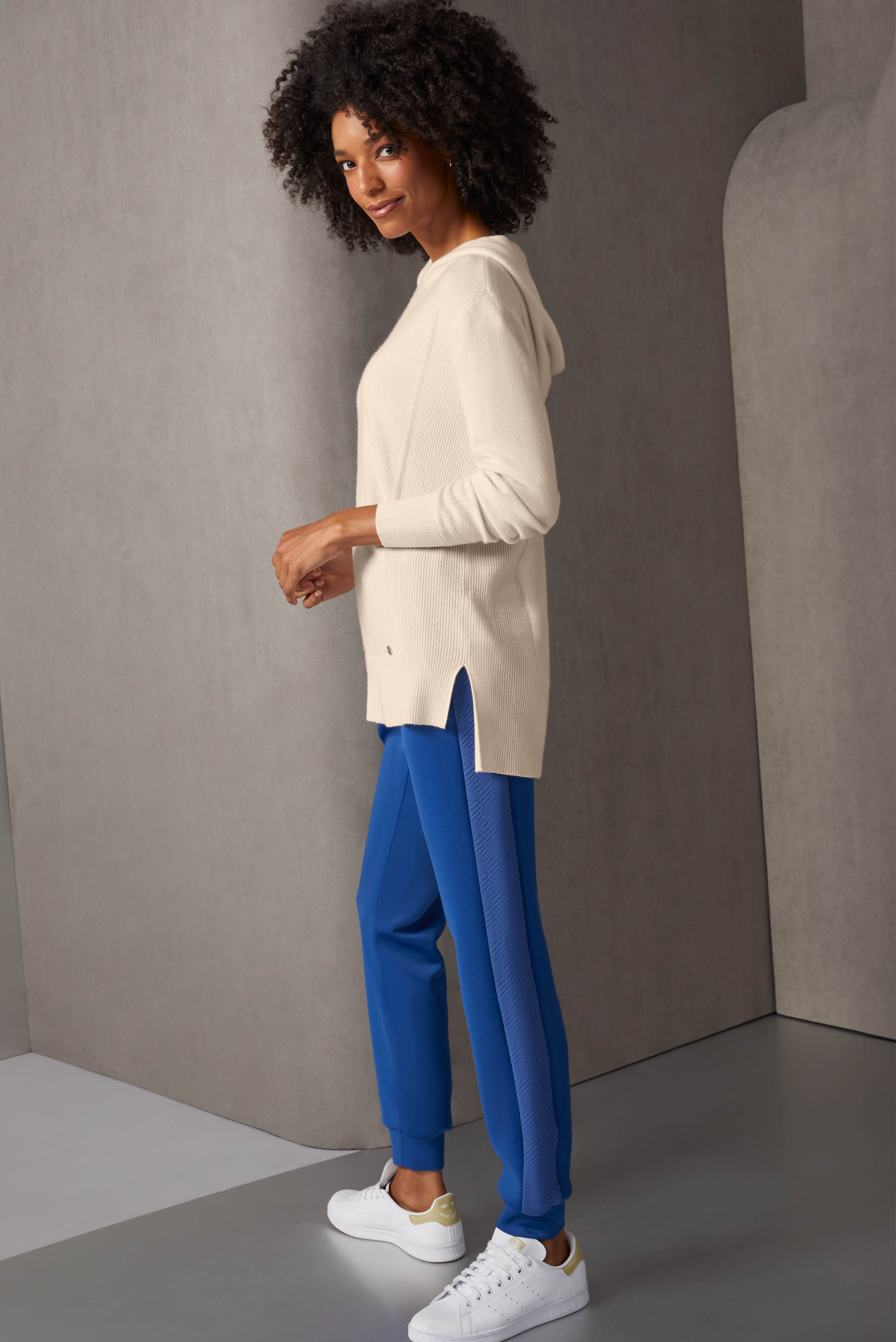 Contrast textures enrich this hoodie and jogger ensemble in creamy tapioca and bright nouvean navy. The high-low jersey hoodie is pure cashmere, with rib-knit accents at the sides, cuffs, and slit hem. 