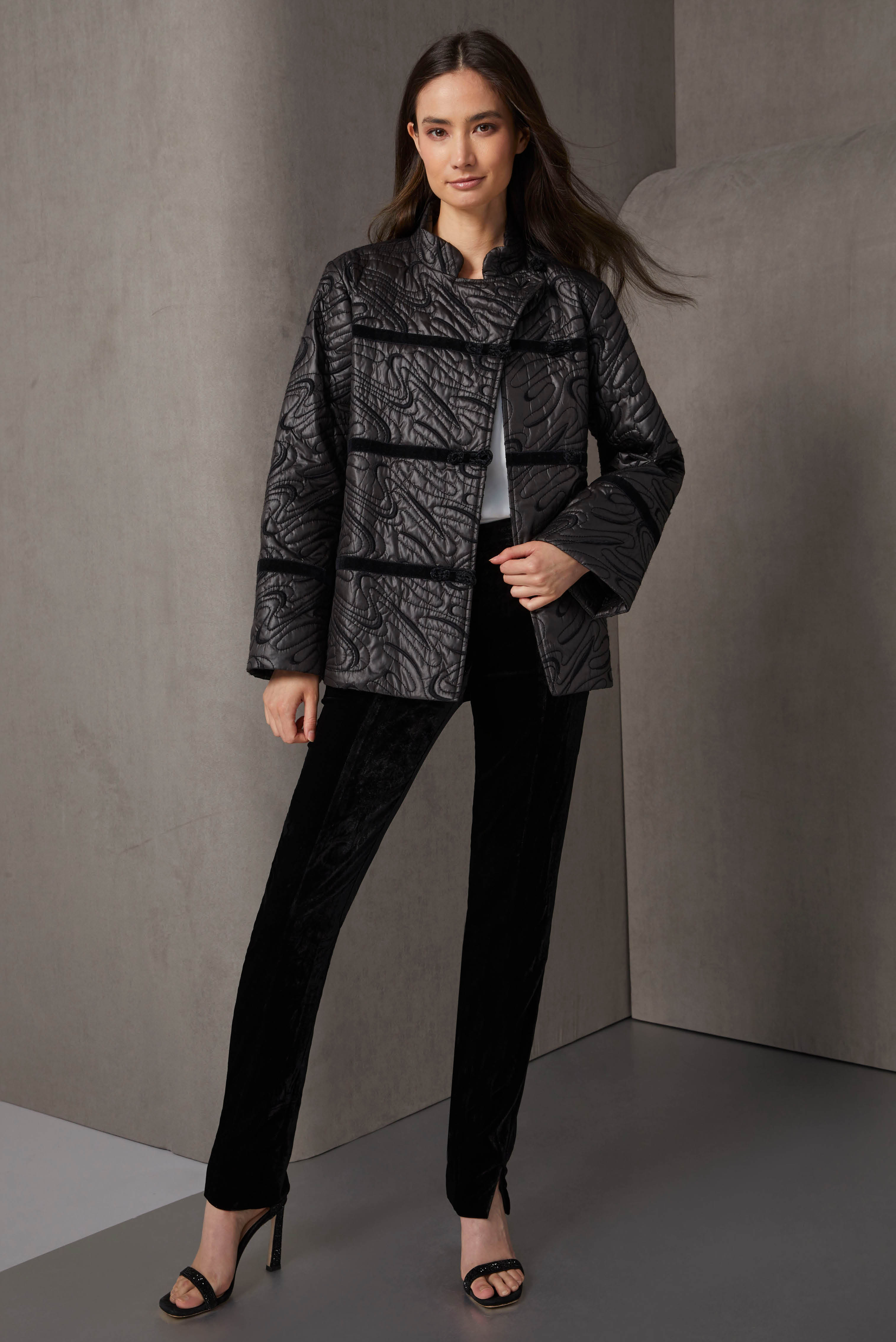 This look is a trend-right column of black with Asian allure in sumptuous materials. The Mandarin jacket features swirling topstitching and embroidery, velvet passementerie, and luxe frog closures.