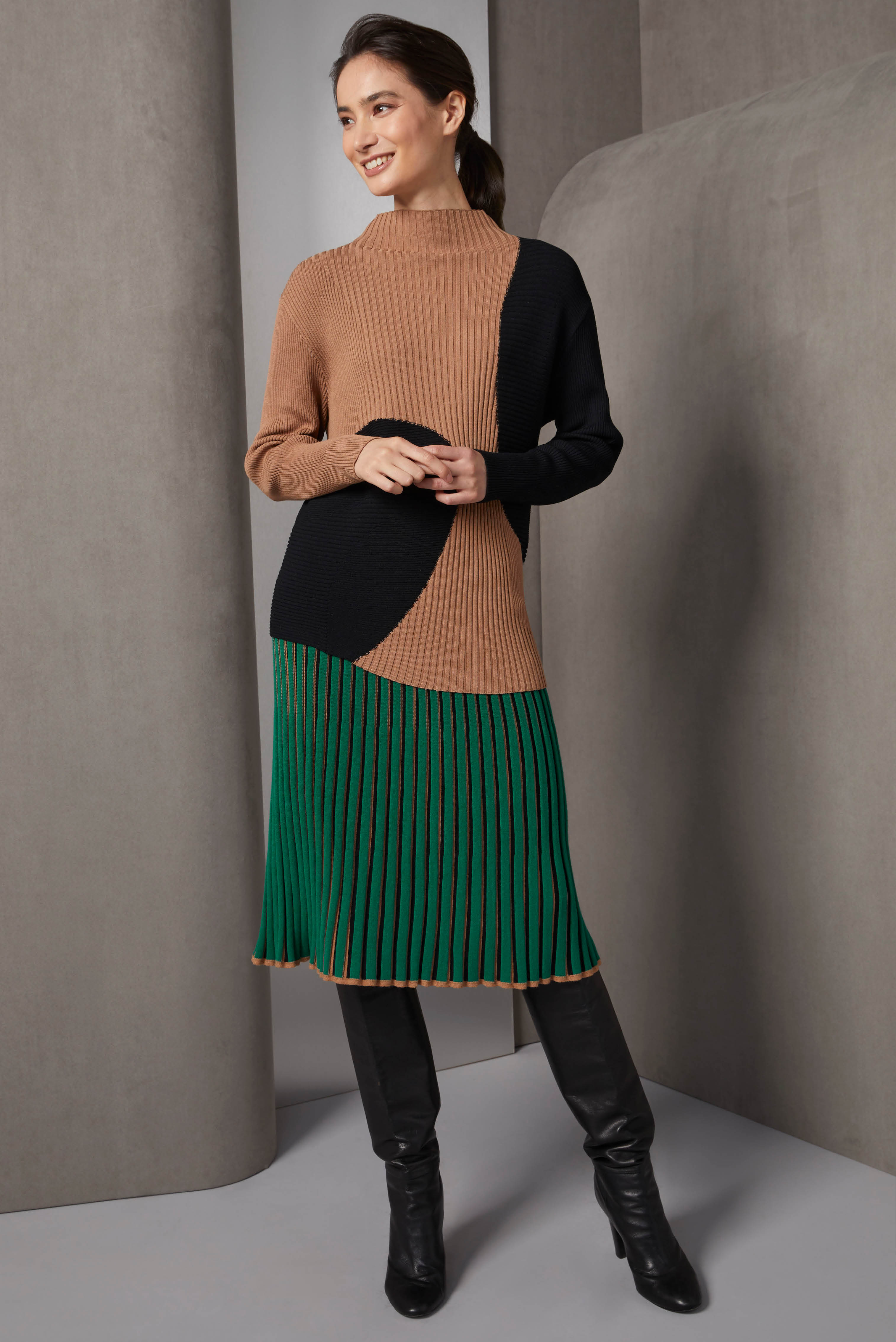 Striking free-form intarsia knit colorblock sweater, featuring a curvy asymmetrical hem in various lengths. This standout knit comes to life with multi-width, multi-directional ribs that add a dynamic texture. 
