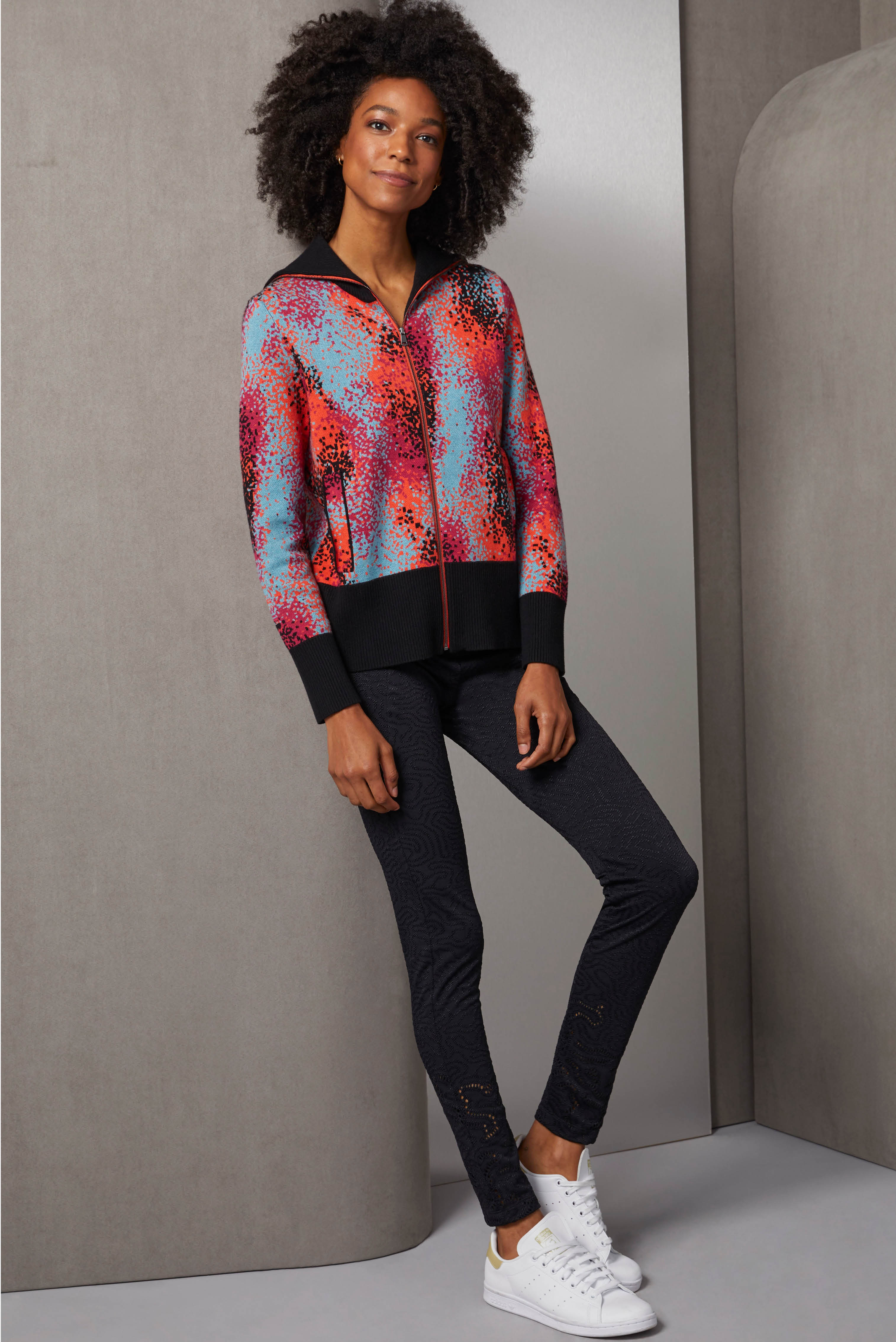 This sporty ensemble includes three standout luxury pieces. The bomber jacket is a birdseye knit jacquard with an airbrushed-look pattern of spicy orange, pink, aquamarine, and black.