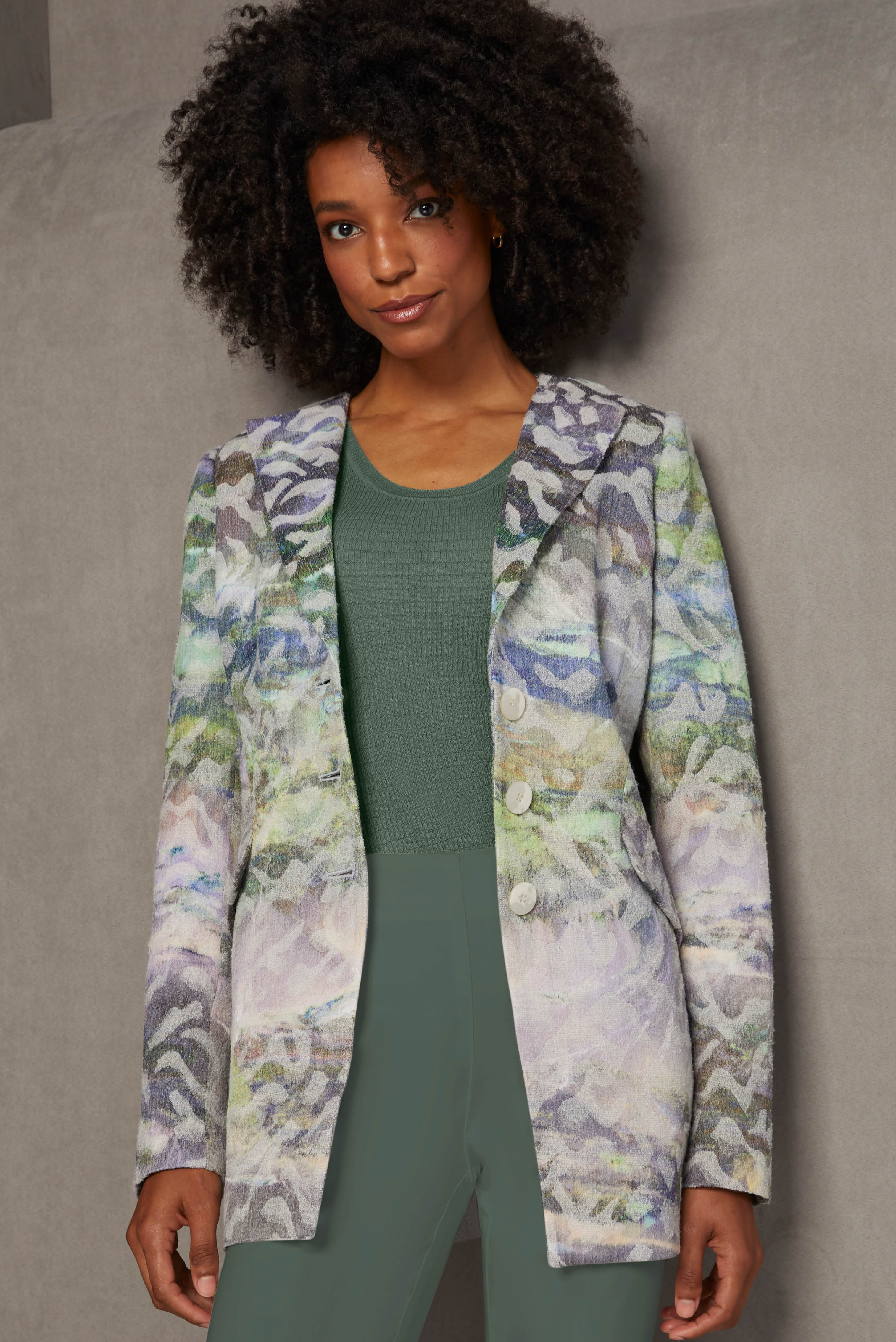 This unique Italian jacquard jacket features an abstract leaf pattern resembling a forest at sunset, set against an ombré background. Picking up the sylvan theme are a knit top and pants in laurel wreath green.