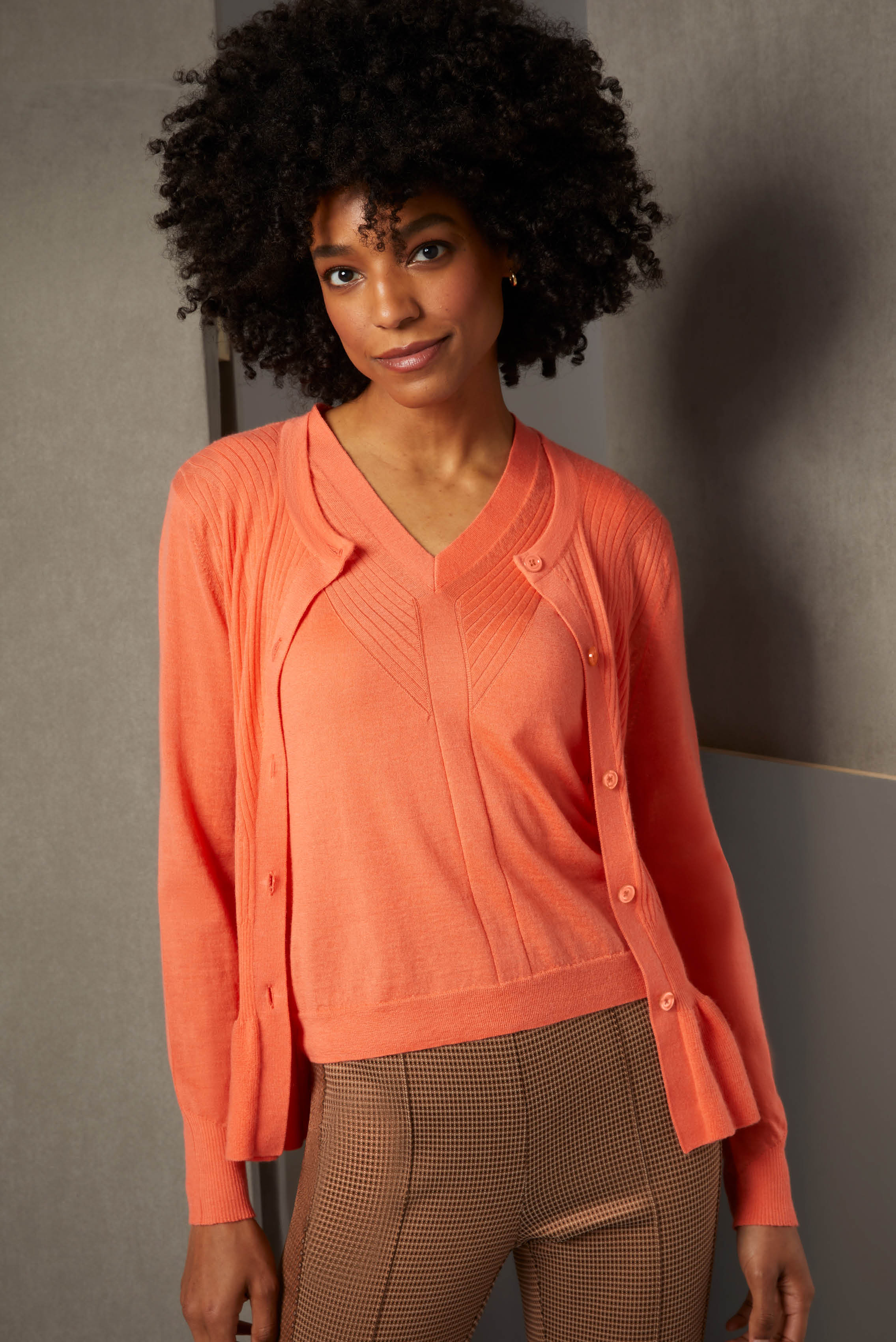 Pattern plays a role in this upscale ensemble. The bold apricot cashmere twinset accents outfits with color, traveling ribs, and a feminine peplum. Equally complex are these stretch satin jacquard pants in a mini-oval pattern.
