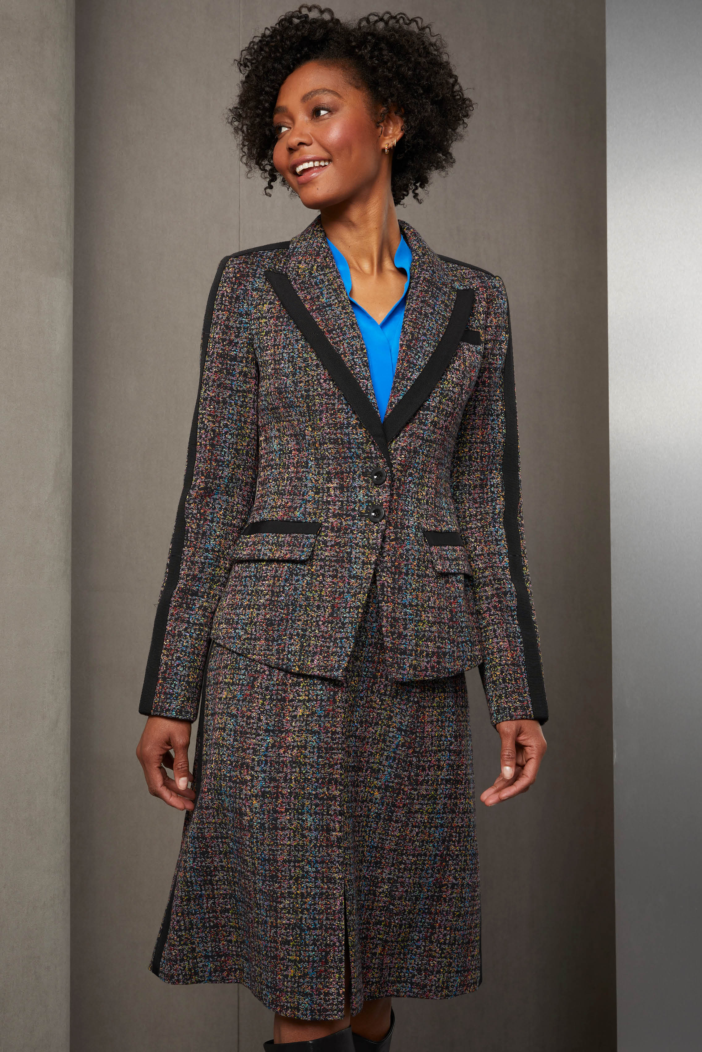 Seize the day in stylish comfort. The eight-color Italian tweed skirt suit showcases the atelier tailoring of flawlessly placed black ribbon trim. The smart cutaway of the jacket is echoed by the front notch of the skirt.