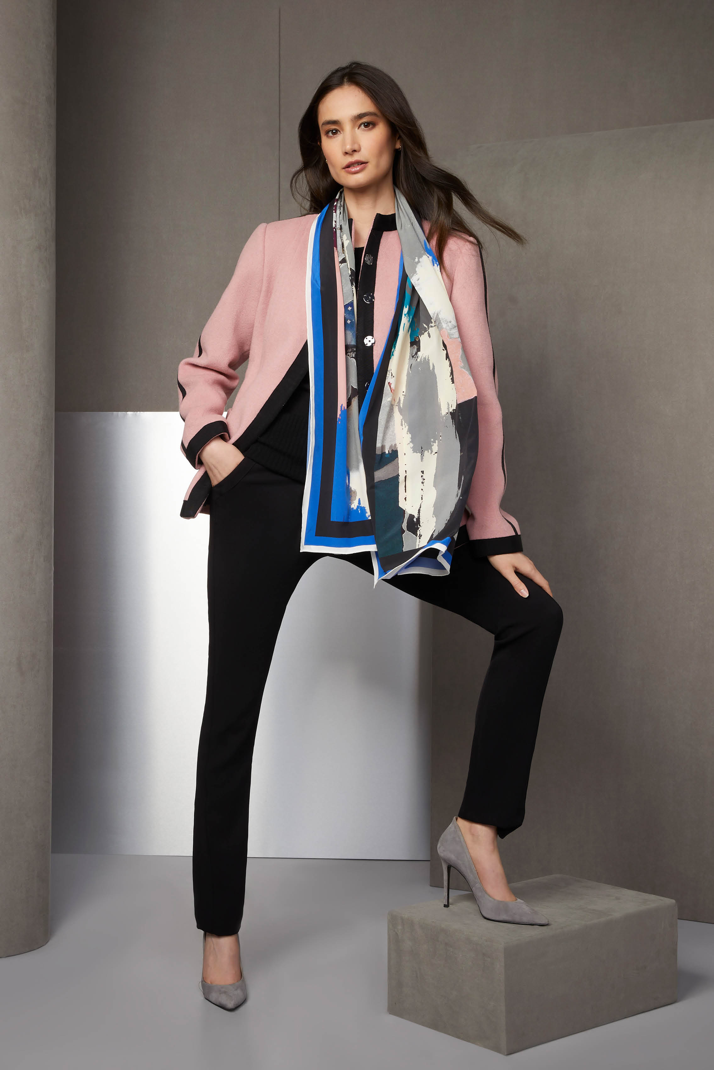 This look combines military chic, formal attire, and unabashed opulence. The pink wool-blend cadet jacket is trimmed in black grosgrain ribbon. The fluid black crêpe pants have applied tuxedo stripes.