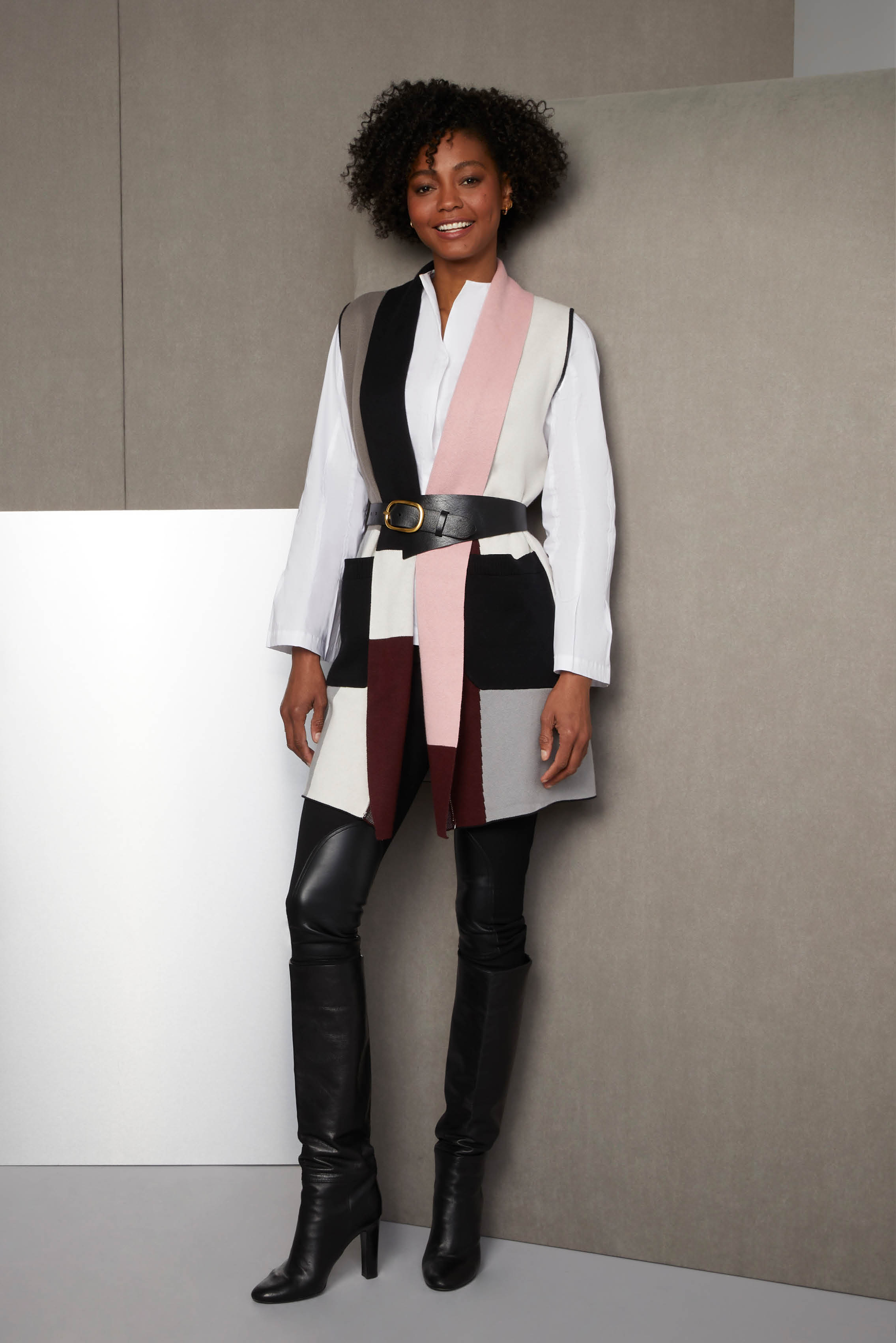 Unleash your avant-garde stylist. This silk-softened cotton sweater vest is a work of Cubist intarsia in six hues. The white blouse has a flared hem and cuffs formed by front and back release pleats.
