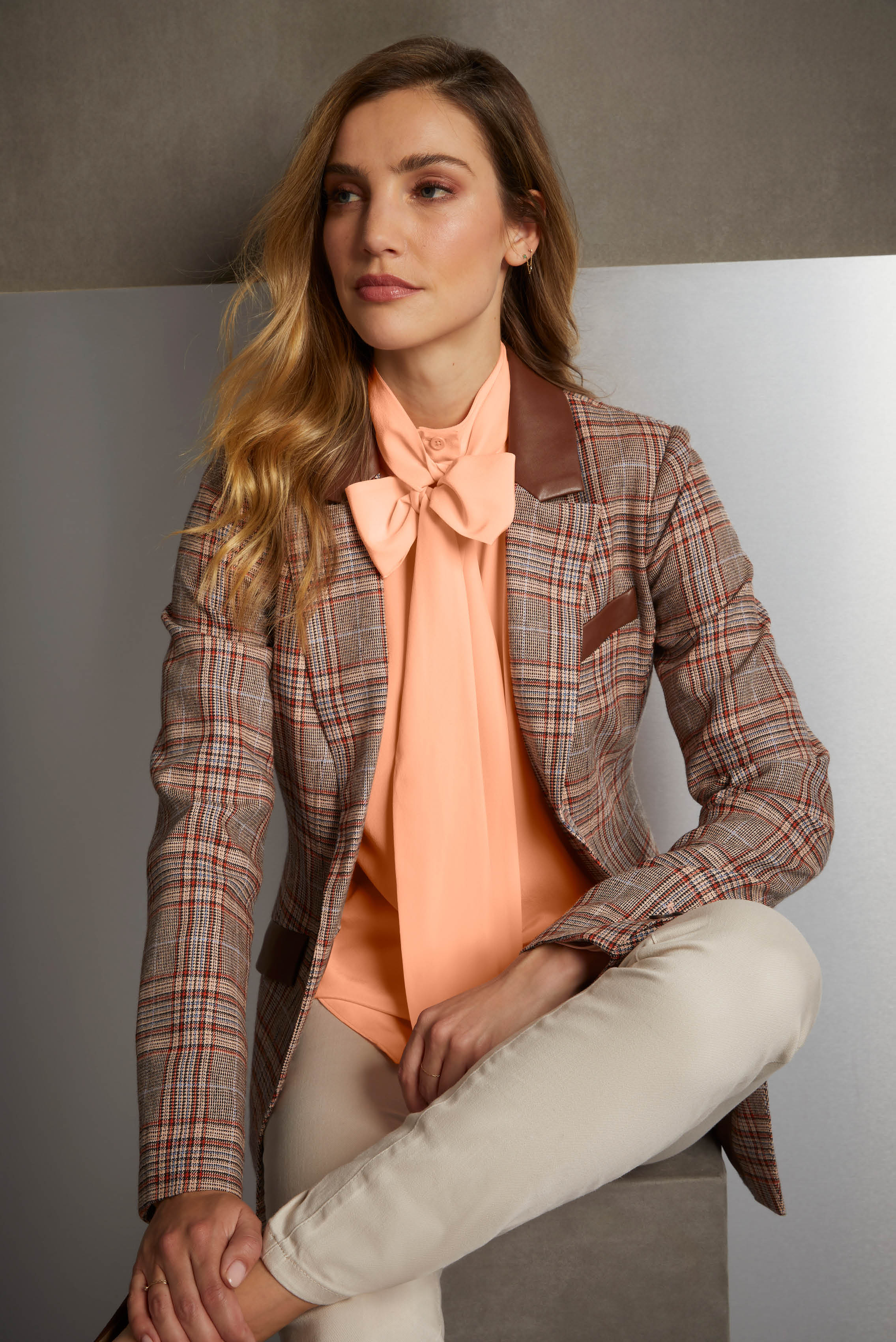 Express a feminine narrative with an Italian, four-color plaid riding jacket, enhanced with chocolate torte faux leather trim, plus soft shades of peach and apricot.
