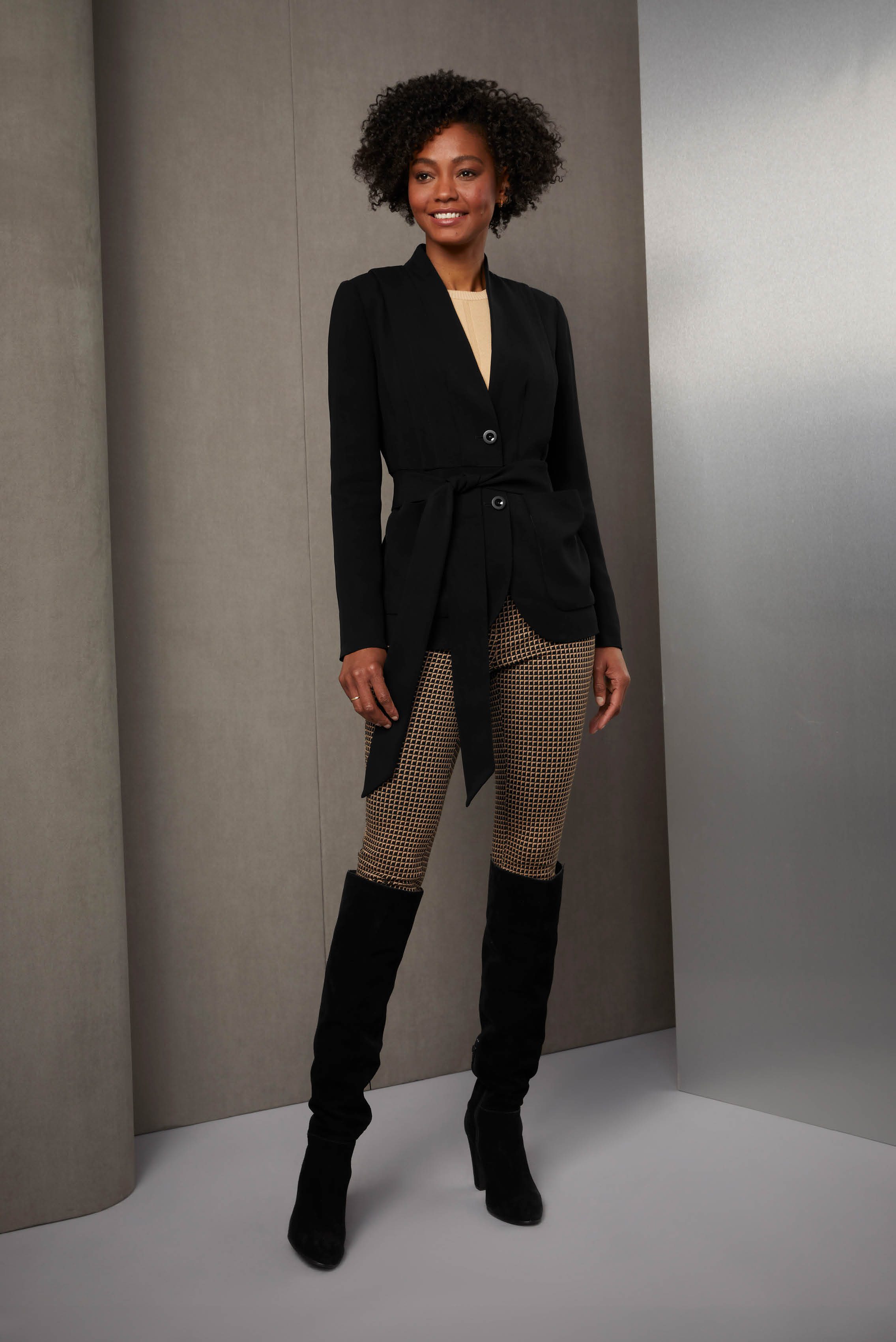 Dress to impress in fluid crêpe, Italian jacquard, and sustainable merino wool knit. The softly tailored black crêpe jacket has a long self sash for carefree flair. The skinny pants are a black and camel.