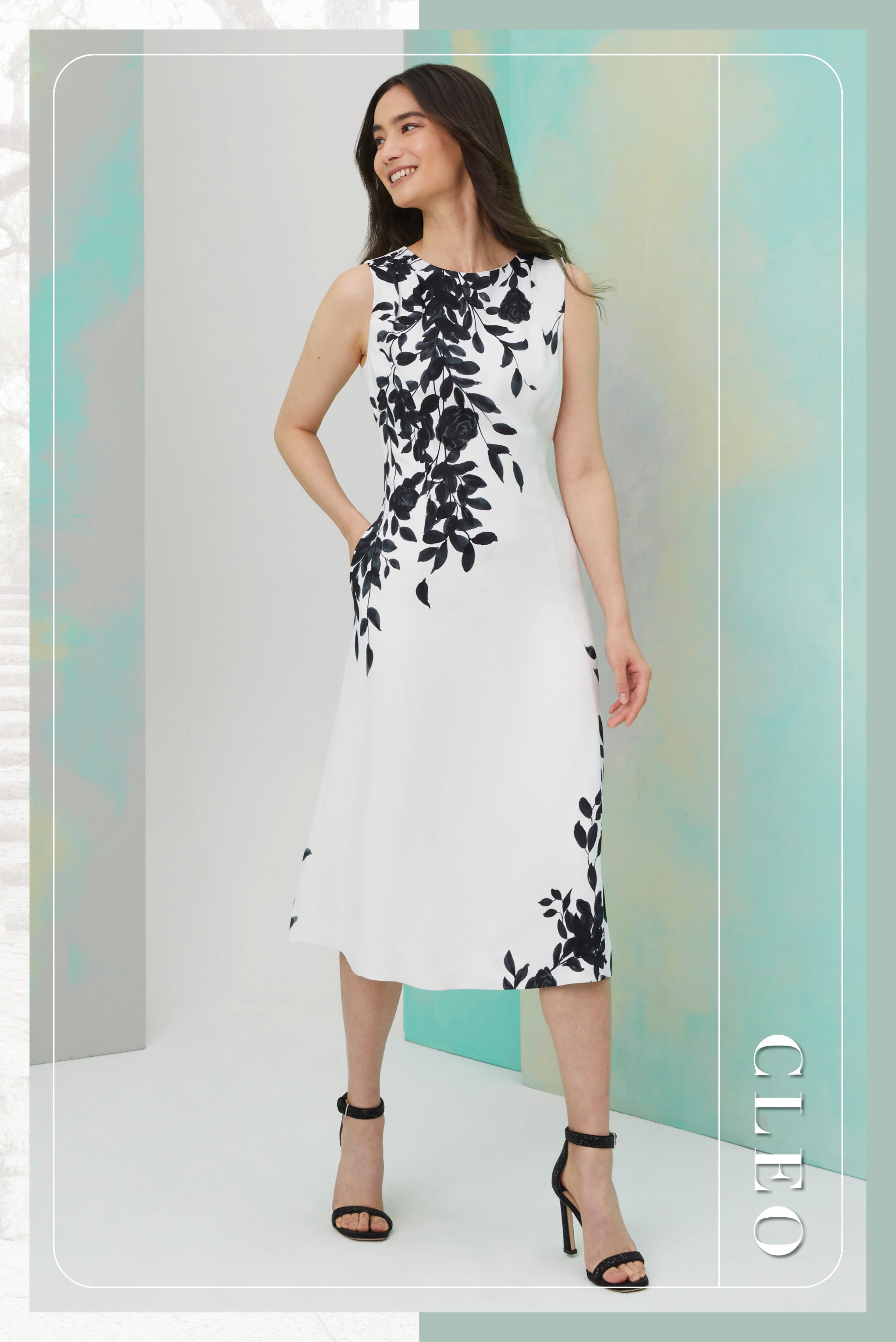 Photo of a model wearing the Cleo dress, a floral print white crêpe dress.