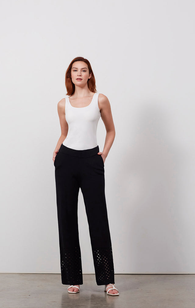 Ecomm photo of a model wearing the Vibrato pants, which is a knit cotton pants with open triangle stitches.