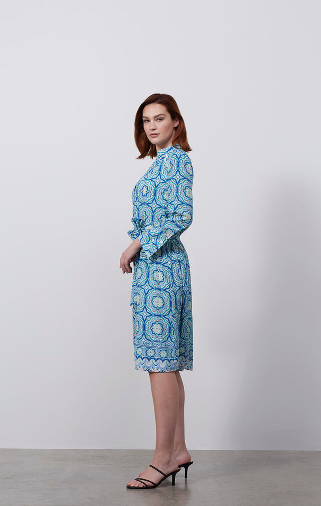 Ecomm photo of a model wearing the Printemps dress, whcih is a stretch silk, tile-print shirt dress.