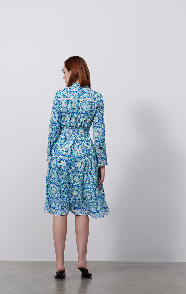 Ecomm photo of a model wearing the Printemps dress, whcih is a stretch silk, tile-print shirt dress.