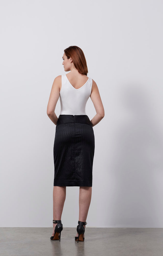 Ecomm photo of a model wearing the Goya skirt, which is an Italian herringbone stretch jacquard skirt.