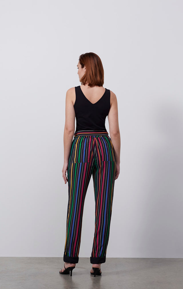 Ecomm photo of a model wearing the Parade pants, which is a colorful placed pinstripe convertible pants.