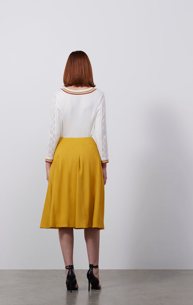 Ecomm photo of a model wearing the El Dorado skirt, which is a wide-sweep Italian stretch linen skirt.
