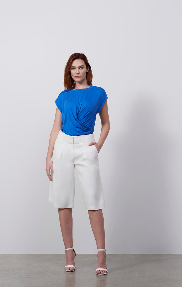 Ecomm photo of a model wearing the Jaunt-Wht pants, which is a Italian linen twill Bermuda shorts 