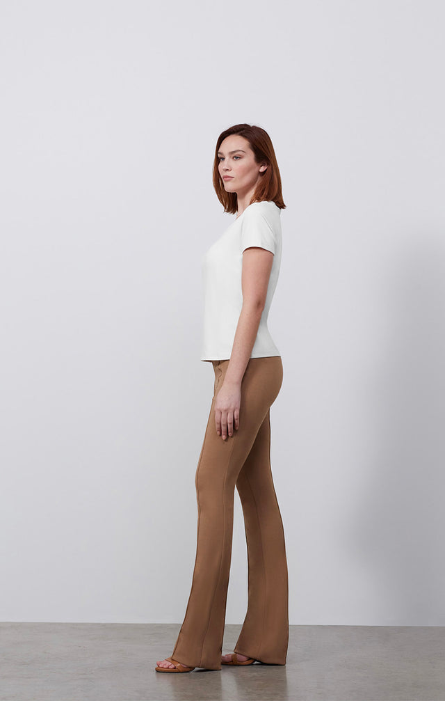 Ecomm photo of a model wearing the Paradigm-Wht shirt, which is a fitted white v-neck tee shirt.