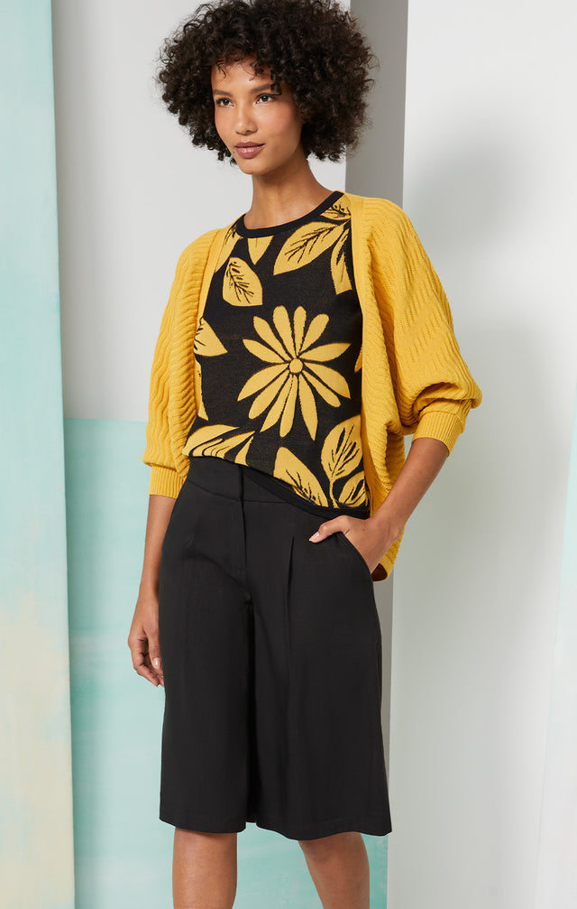 Lookbook photo of a model wearing the Golden-Shell, which is a floral intarsia knit shell.